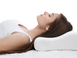 Frau mit verspanntem Nacken liegt auf ein Nackenstützkissen