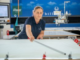 Frau mit blonden Haaren bedient die Steppmaschinen