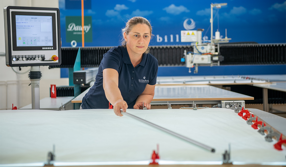 Frau mit blonden Haaren bedient die Steppmaschinen