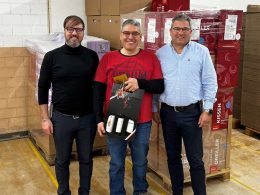 Giuseppe di Mariano, Javier Mendoza und Guido Stutz posieren für die Kamera. Javier Mendoza hält das Jubiläumsgeschenk in der Hand.