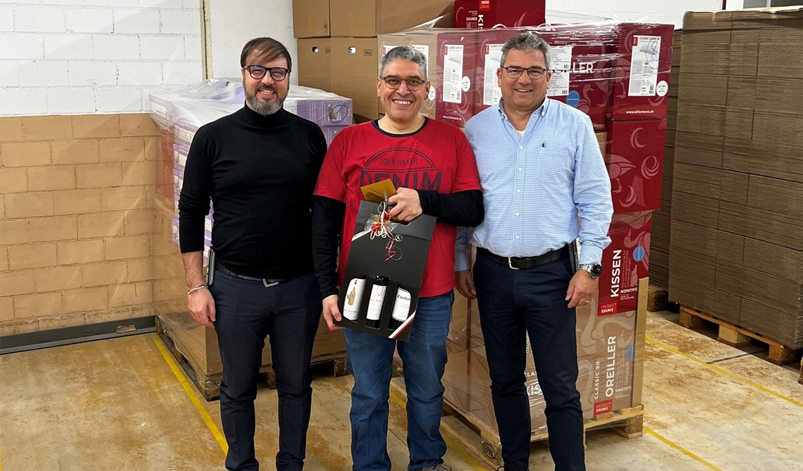 Giuseppe di Mariano, Javier Mendoza und Guido Stutz posieren für die Kamera. Javier Mendoza hält das Jubiläumsgeschenk in der Hand.