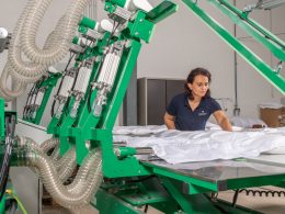 Mitarbeiterin kontrolliert die Befüllung eines Daunen-Duvets an einer industriellen Fertigungsanlage – moderne Produktion von Allergiker geeigneten Naturbettwaren.“