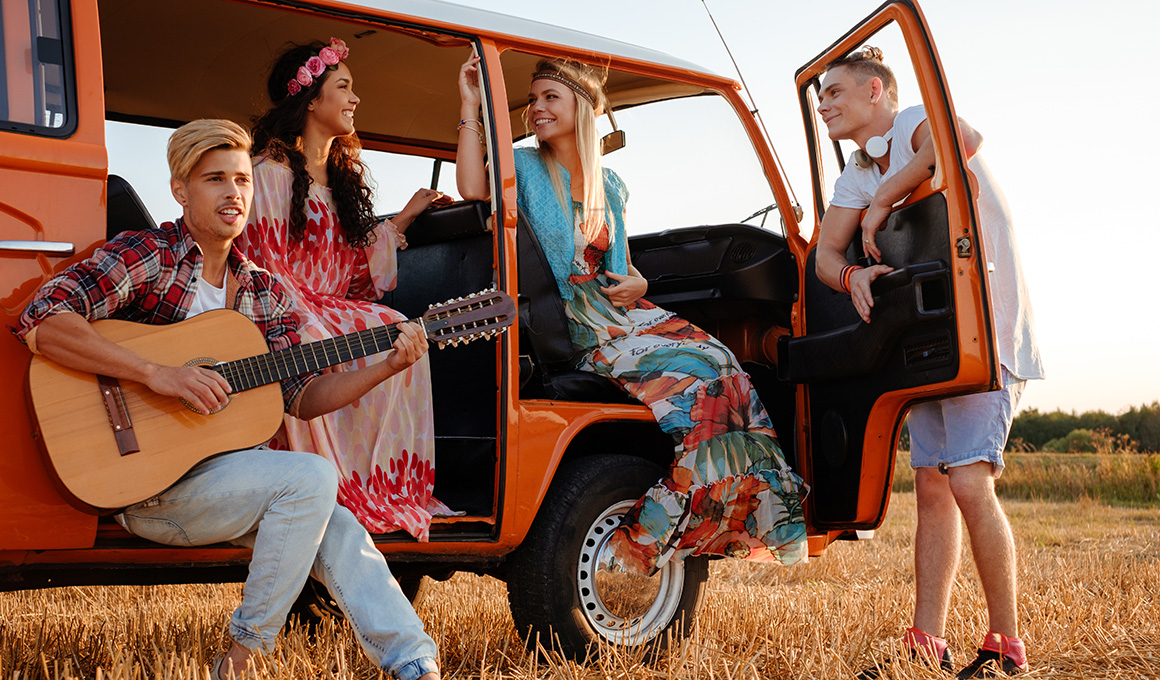 Junge Menschen entspannen am Camper in der Abendsonne – Symbolbild für erholsamen Schlaf auf Reisen und Tipps für guten Schlaf im Urlaub.