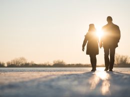 Paar spaziert bei Sonnenuntergang im Winter – Symbolbild für gesunde Routinen, frische Luft und Tageslicht als Hilfen zur Anpassung an die Winterzeitumstellung.