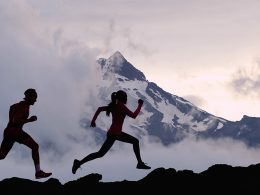 Zwei Menschen joggen in der Natur vor beeindruckender Bergkulisse – Symbol für den Kontrast zwischen analoger Bewegung im Freien und digitaler Schlafüberwachung im Alltag.