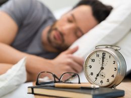 Mann mit schwarzen Haaren und grauem T-Shirt im Schlaf.