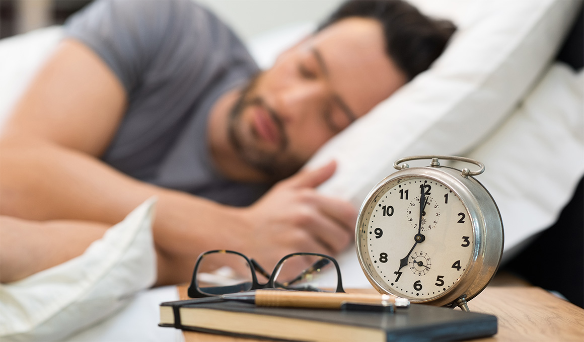 Mann mit schwarzen Haaren und grauem T-Shirt im Schlaf.