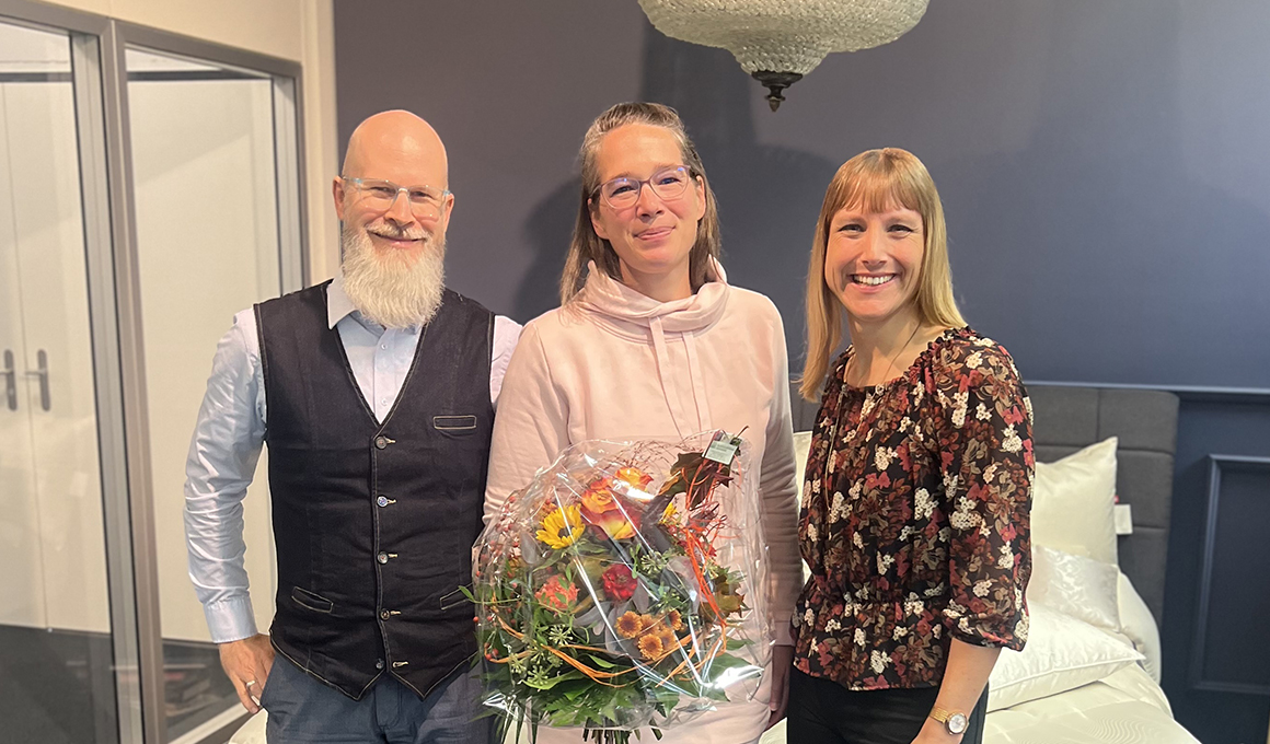 Bruno Zimmermann links, Tanja Kölliker in der Mitte und Sandra Stämpfli rechts lächeln für die Kamera. Tanja Kölliker hält einen Blumenstrauss in der Hand.