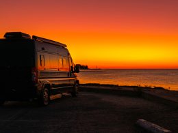 Wohnmobil für die Ferien parkiert am Strand. Blick aufs Meer.