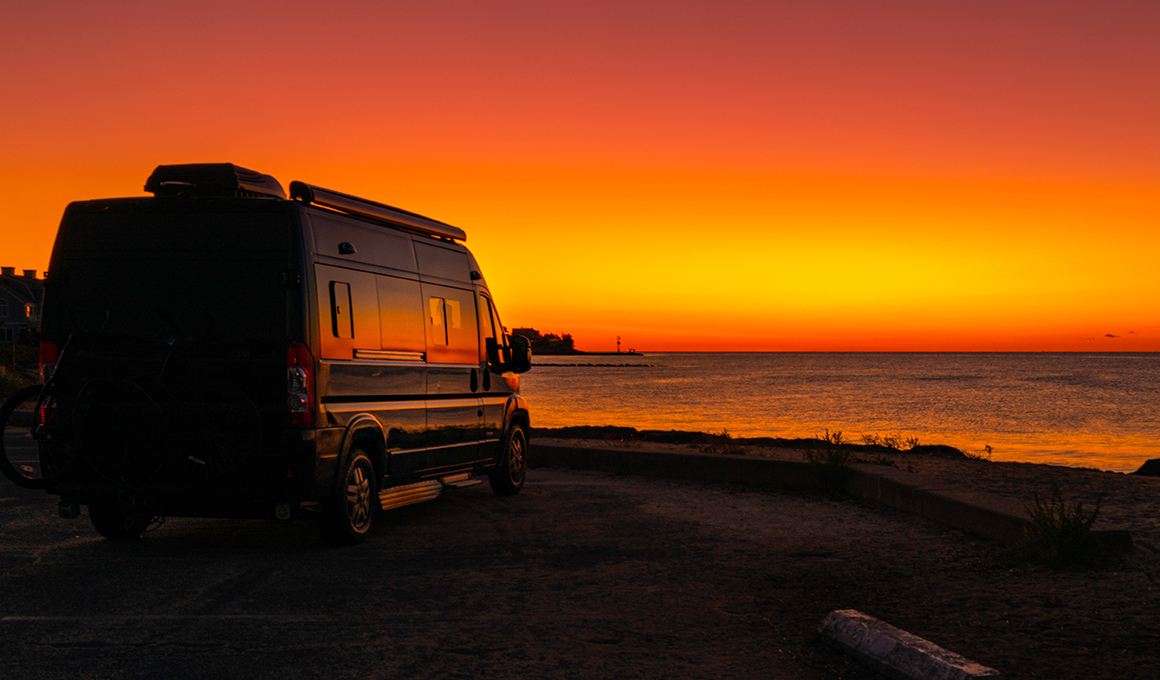 Wohnmobil für die Ferien parkiert am Strand. Blick aufs Meer.