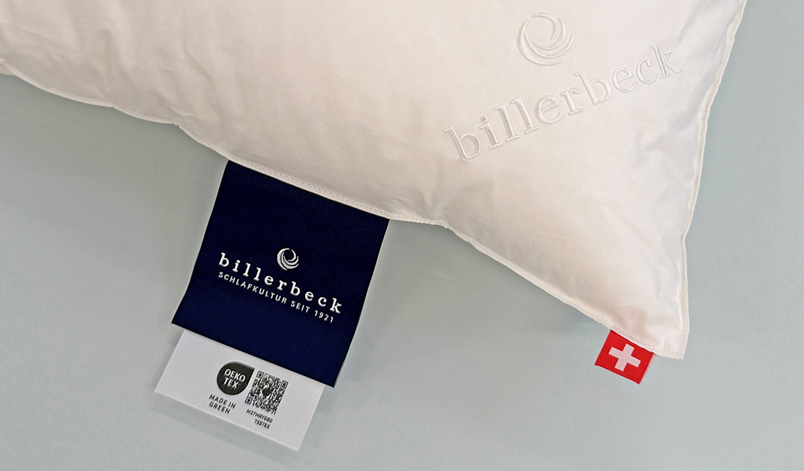 Detailansicht eines billerbeck-Kissens mit der billerbeck-Etikette. Unterhalb der Etikette sind das Made-in-Green-Logo sowie der zugehörende QR-Code sichtbar.