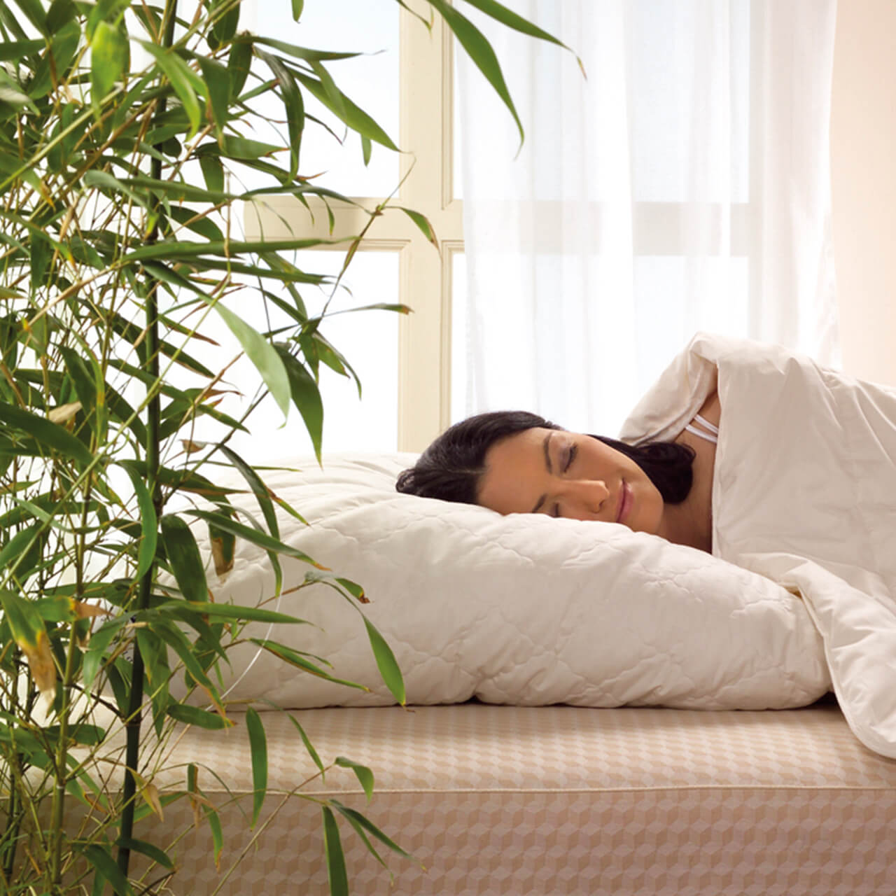 Frau liegt auf Bett im Schlafzimmer mit der billerbeck Bambusdecke E45 Bamboo