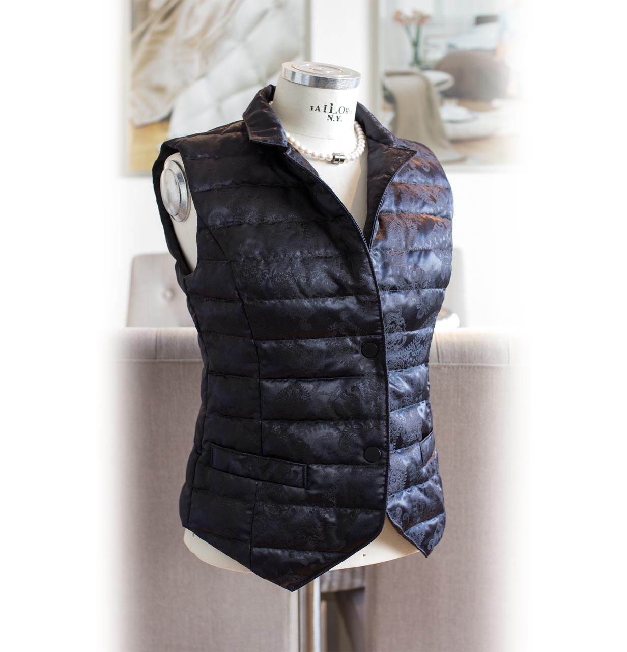 Side view of the billerbeck down vest for women with 100% silk in black, on bust with background